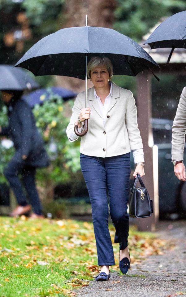  Theresa May walks in the rain as Brexit debate pours across the UK