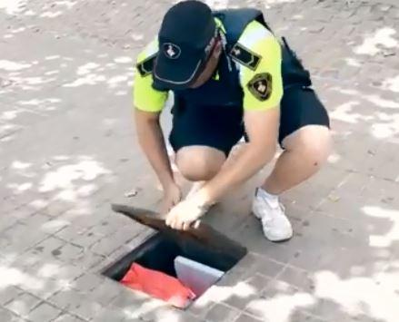  A police officer opens a drain to reveal a cocktail makers stash of ingredients