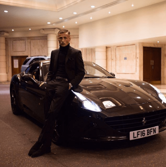  And here, posing next to one of the Ferrari's in his collection