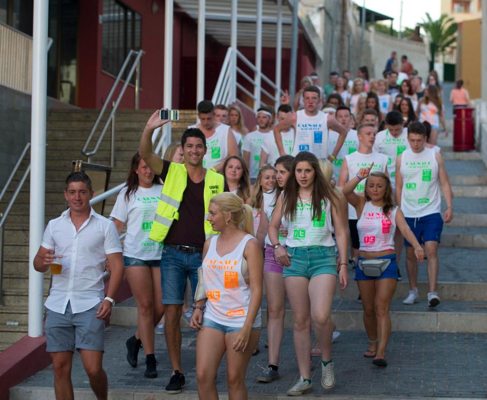  Dozens of party-goers follow a staff member on the Carnage Bar Crawl in Magaluf