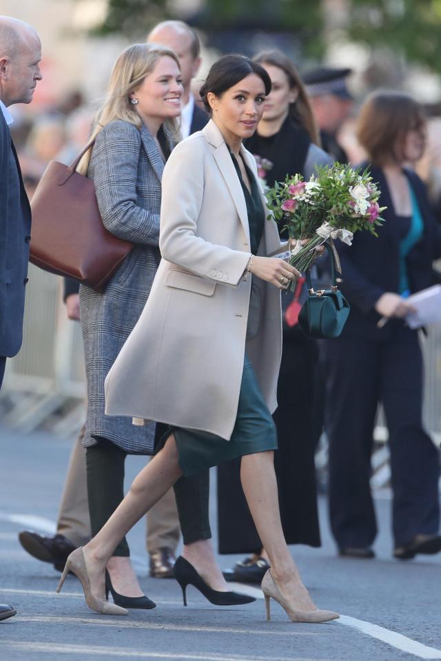  Wearing Kate Middleton-approved nude heels, Meghan clutched flowers given to her by a fan