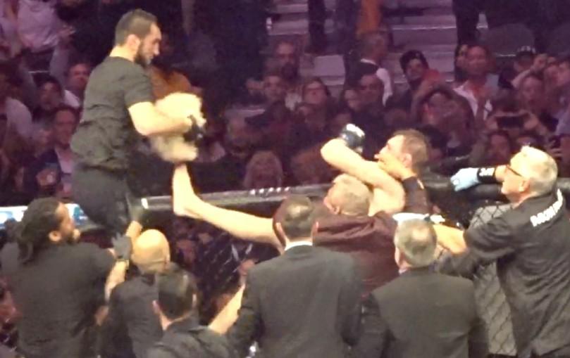  Another man sat on the octagon and tried to hit McGregor from above with a wig in hand