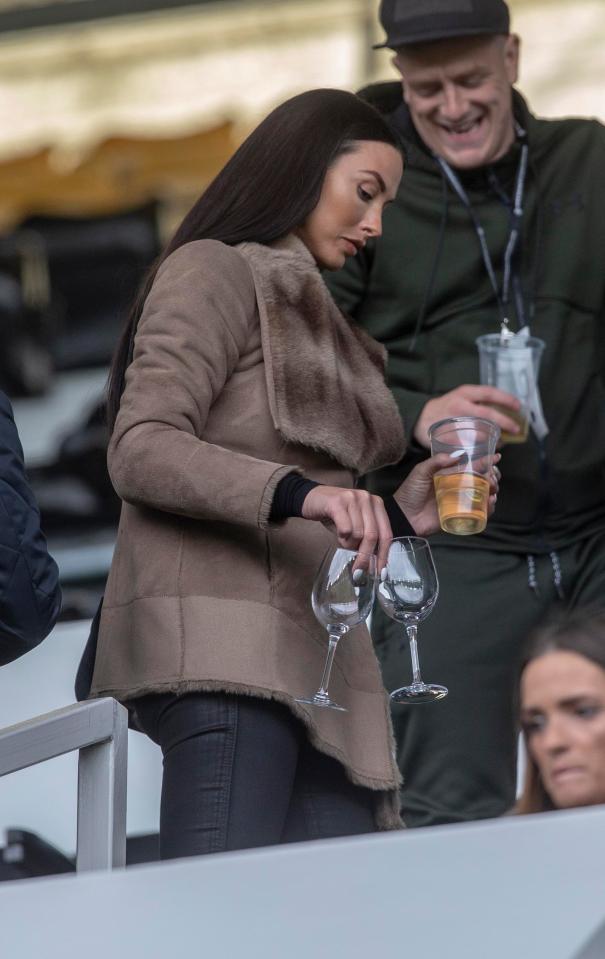  Alice was seen holding a glass of wine in the stands