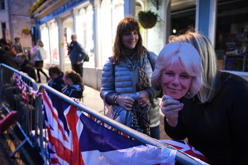  Is that you Camilla? A fan jokingly holds up a mask of Camilla Parker Bowles, who missed the wedding today