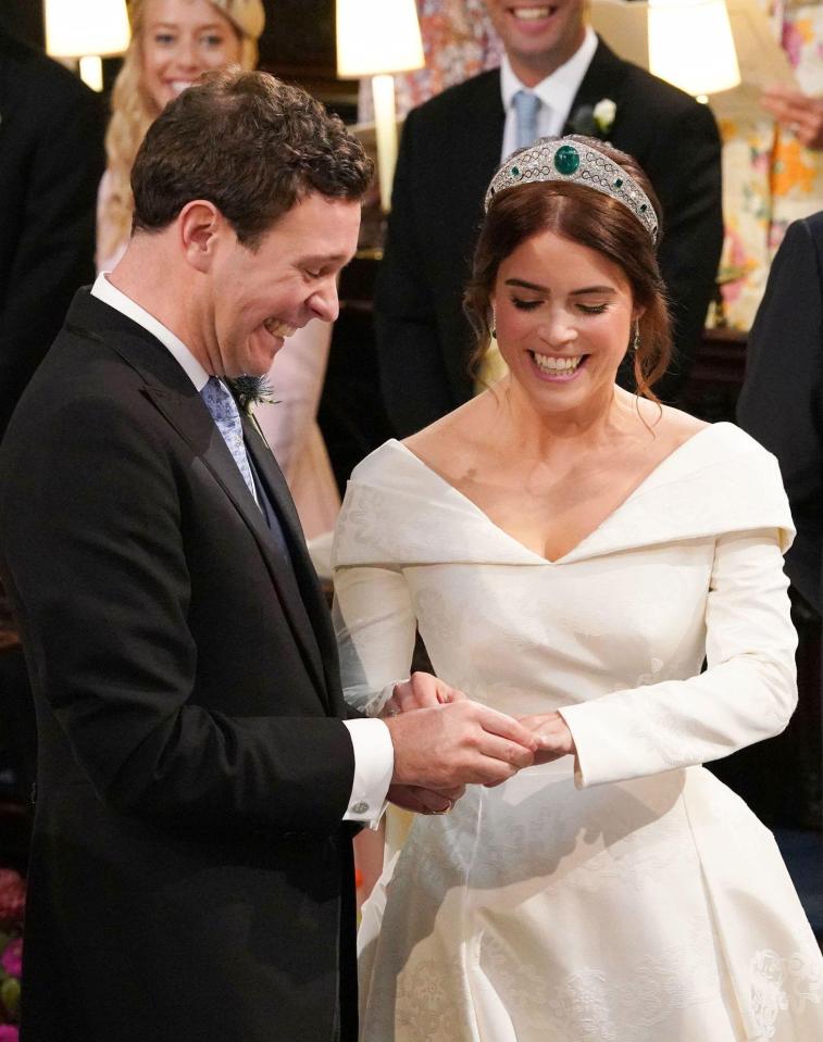  The newlyweds giggle as Jack places a ring on his wife's finger