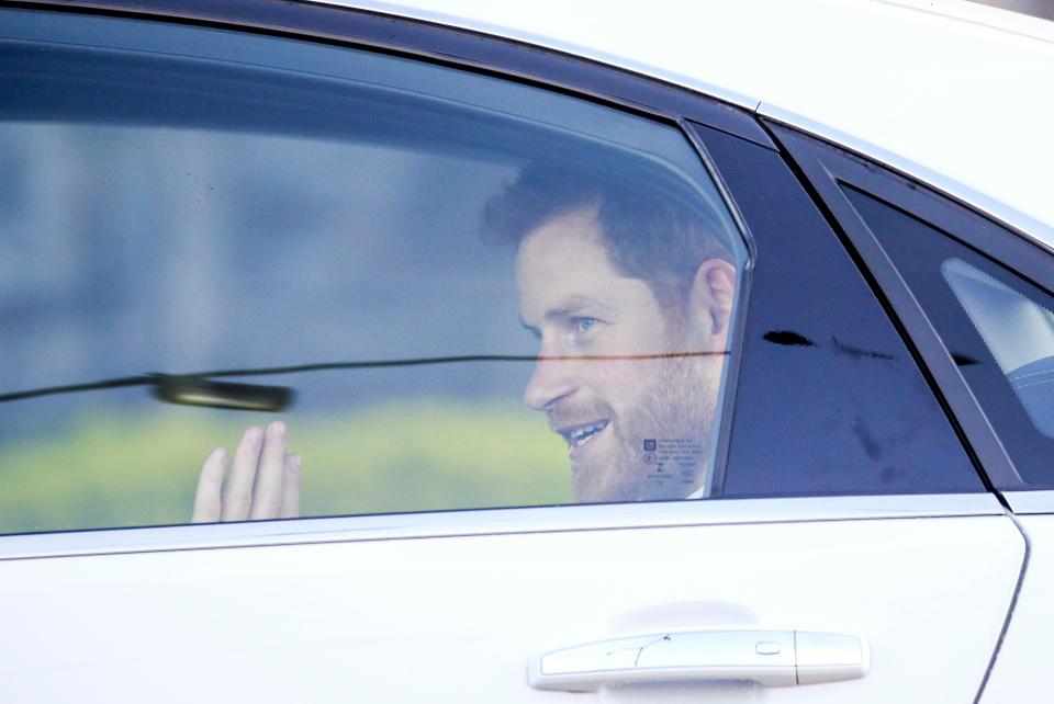  Prince Harry waves as they are whisked from the airport