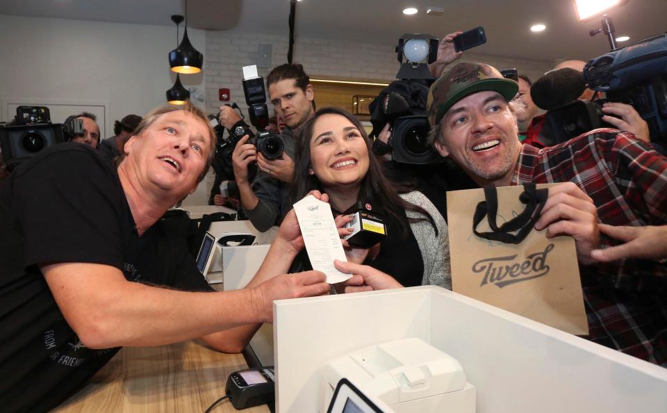  Canopy Growth CEO Bruce Linton, left, poses with the receipt for the first legal cannabis for recreation use sold in Canada