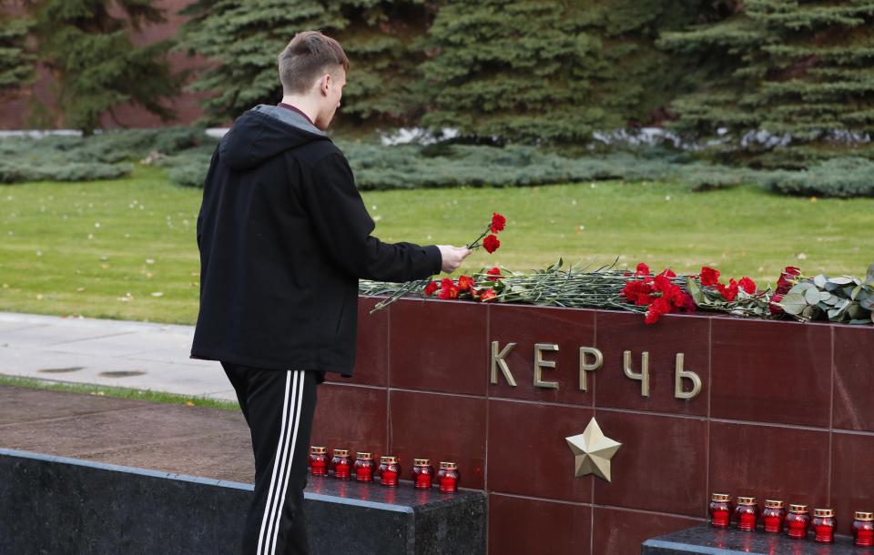  A man lays flowers on the monument in the Alexander Garden of Kerch in mourning for the dead children at a vocational school