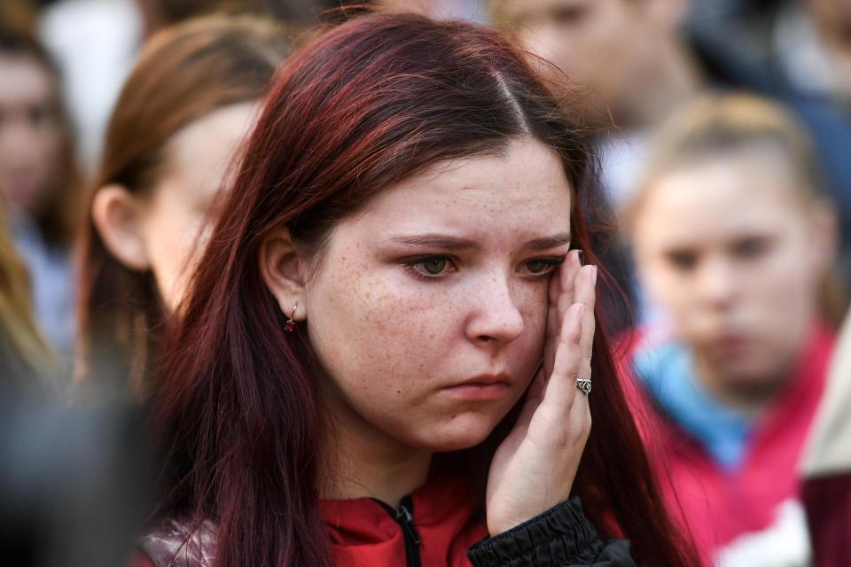  A distressed teenager joins local people at a makeshift memorial near the scene