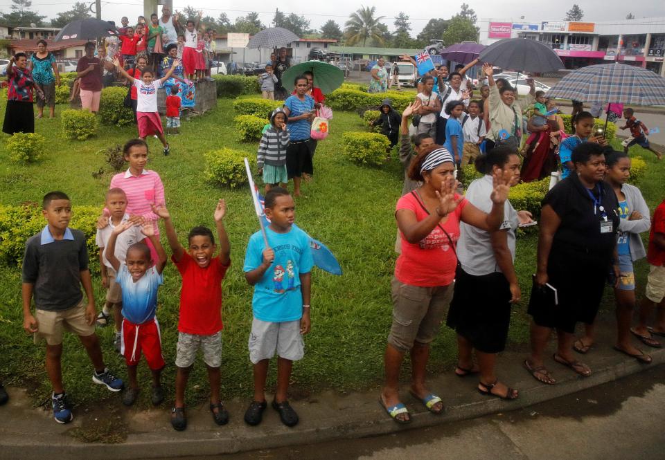  Well-wishers stand along the streets and wave as Harry and Meghan arrive in Suva