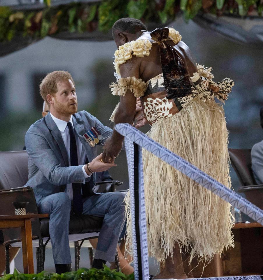  A man in traditional dress hands Harry a cup of local drink Kava as part of the ceremony