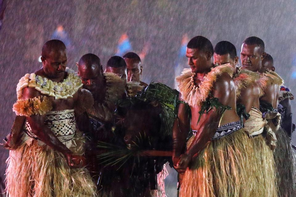  The royal couple are presented with their roasted pig in the pouring rain