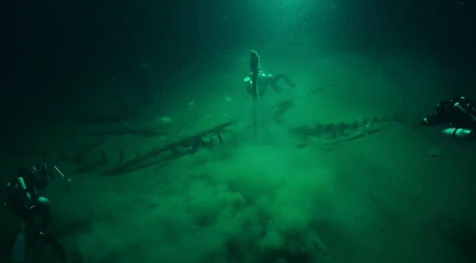  The mast can be seen protruding from the seabed as divers excavate the ship