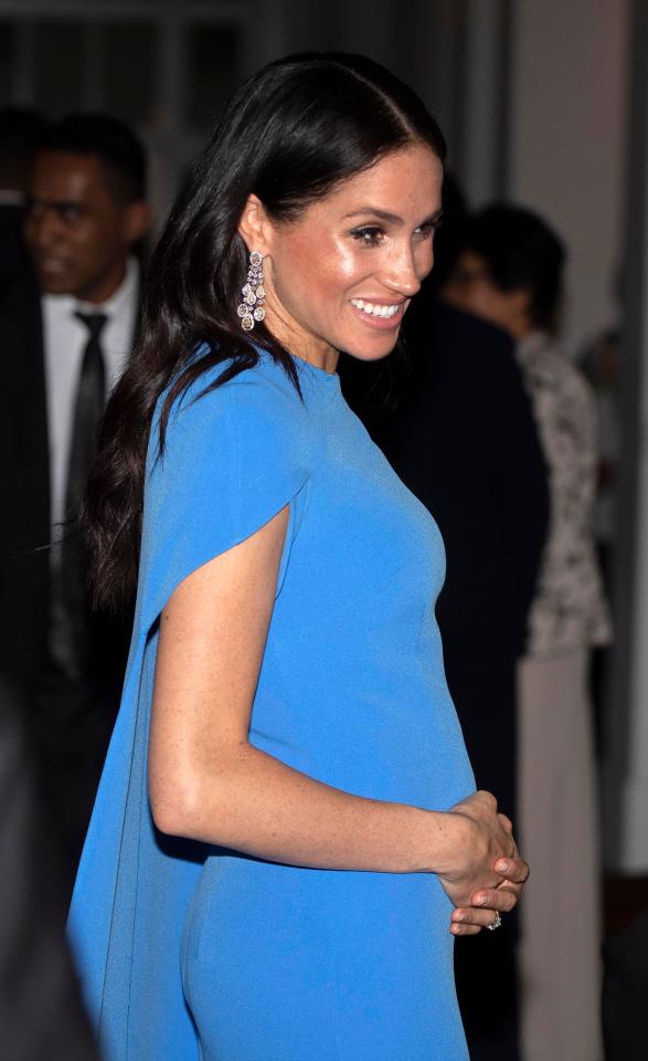  Meghan Markle cradles her baby bump as the couple arrive for a state dinner