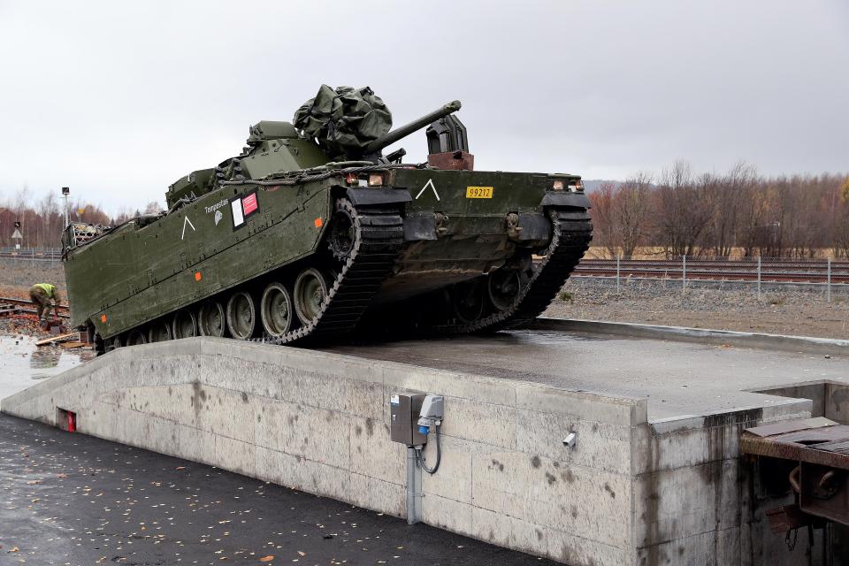  Norwegian armoured infantry combat vehicle driving up a ramp and on to a train during the Nato-led military exercise Trident Juncture