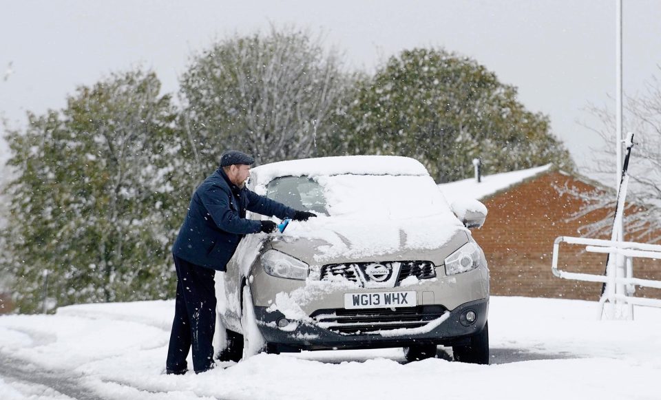  A motorist clears snow from his car window in Stanley, County Durham, in late October 2018