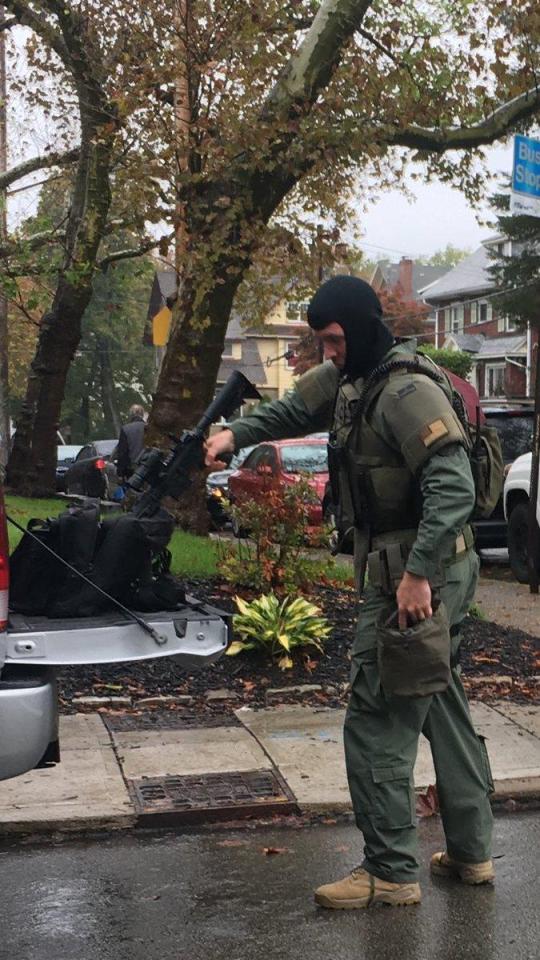  A SWAT member prepares his rifles outside the synagogue after an anti-Semitic gunman opened fire