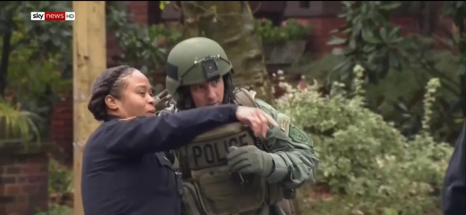  A local resident speaks to a SWAT team officer near the scene of the deadly shooting