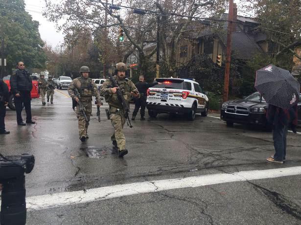  Law enforcement in military fatigues patrol the streets following the shooting