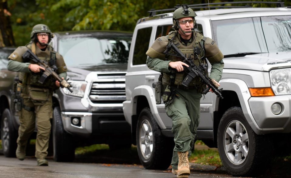  An armed responder runs during the siege of the synagogue