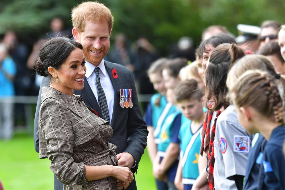  Meghan and Harry share a joke with schoolchildren during an official welcoming ceremony at Government House