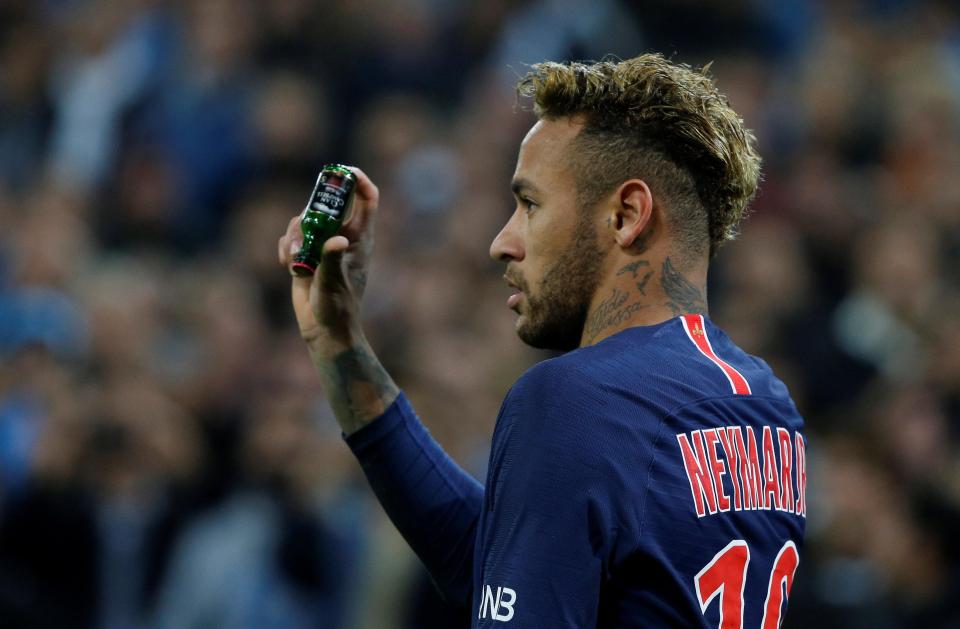  Neymar picks up a bottle thrown in his direction during the clash at Marseille