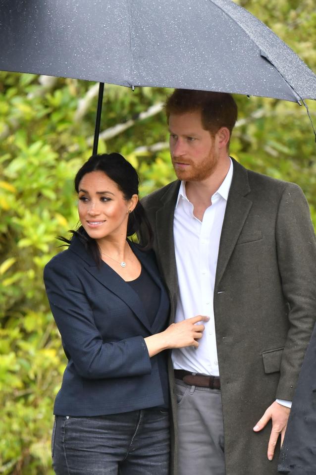  The royal pair look affectionate as they shelter under the same umbrella