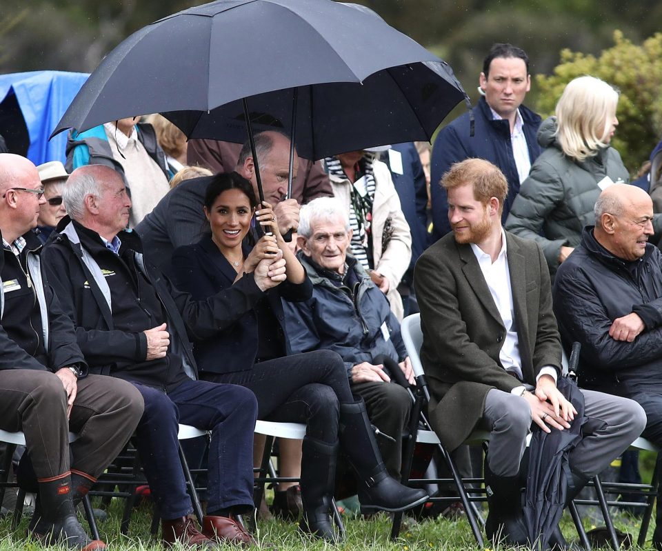  Shelter from the storm... Meghan hides under a brolly as the heavens open