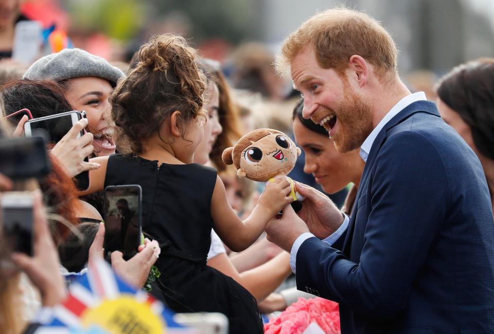  Prince Harry accepts a doll gift from a tot in the audience