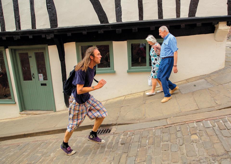  A bold tourist making a breathless ascent up the steep hill in Lincoln called, er, Steep Hill