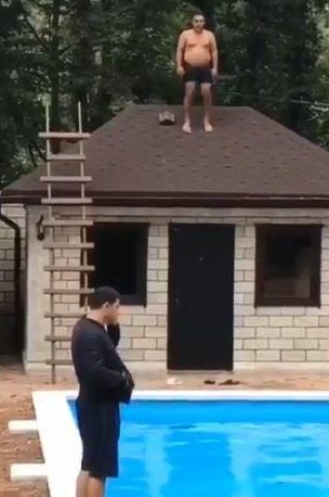  The half-naked daredevil stands on the roof, preparing to jump into the pool below