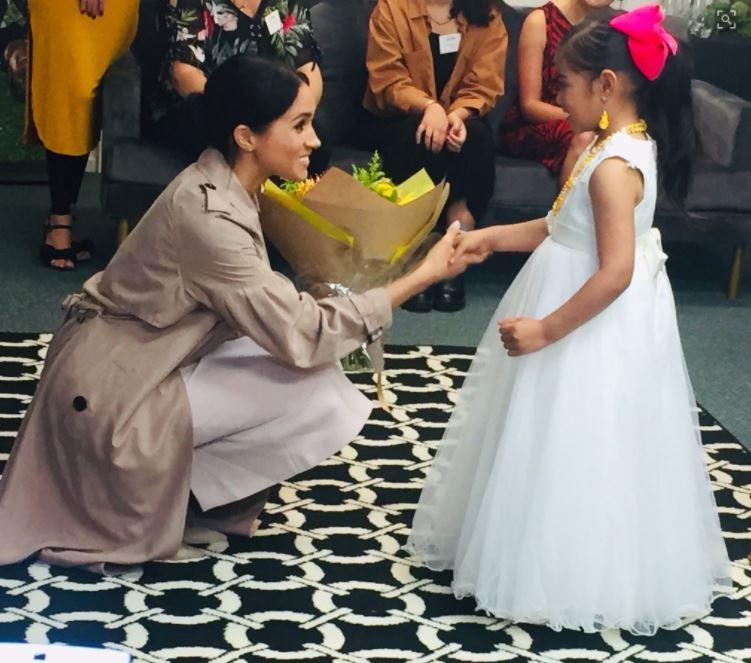  Ghianna Angi, 6, hands Meghan some flowers. She is part of Pillars, a charity that supports children who have a parent in prison