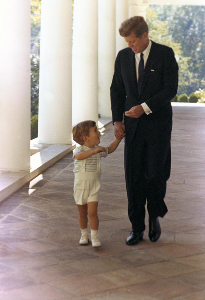  President John F. Kennedy and John Jr walk together in the West Wing Colonnade of the White House on October 10, 1963