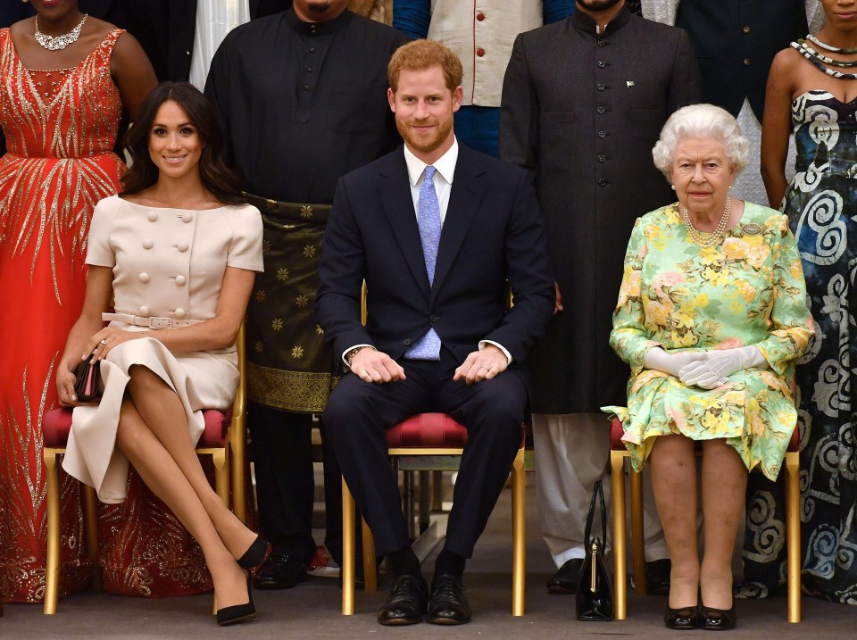 The Queen with the Duke and Duchess of Sussex pose for a picture at a Buckingham Palace reception following the final Queen's Young Leaders Awards Ceremony in June