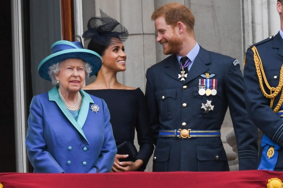 Queen Elizabeth ll, Meghan Markle and Prince Harry on the balcony of Buckingham Palace during a flypast to mark the centenary of the Royal Air Force in July