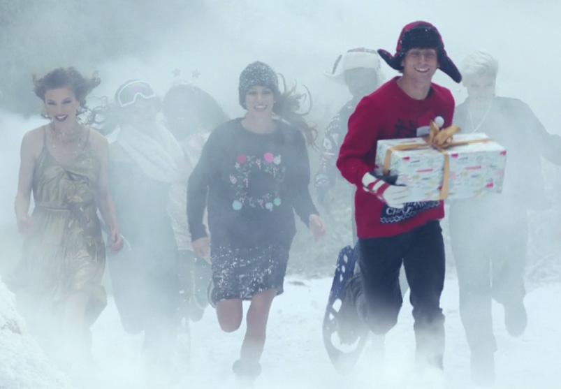  People celebrating Christmas run through the snow carrying presents in the advert