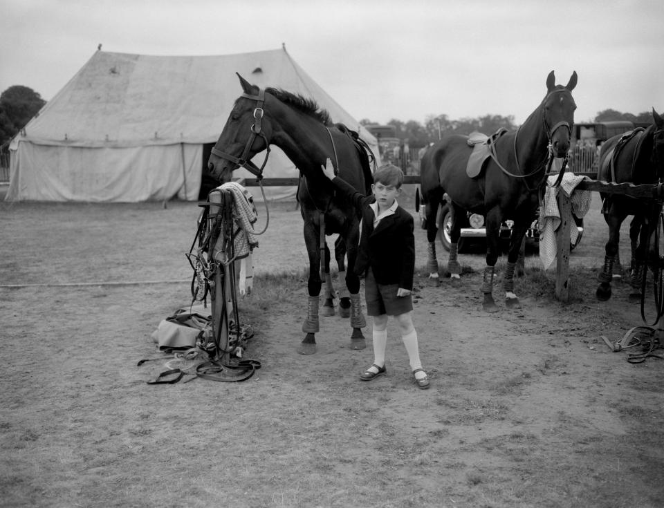  1956: Prince Charles giving a friendly pat to one of the ponies at Smith's Lawn, Windsor Great Park