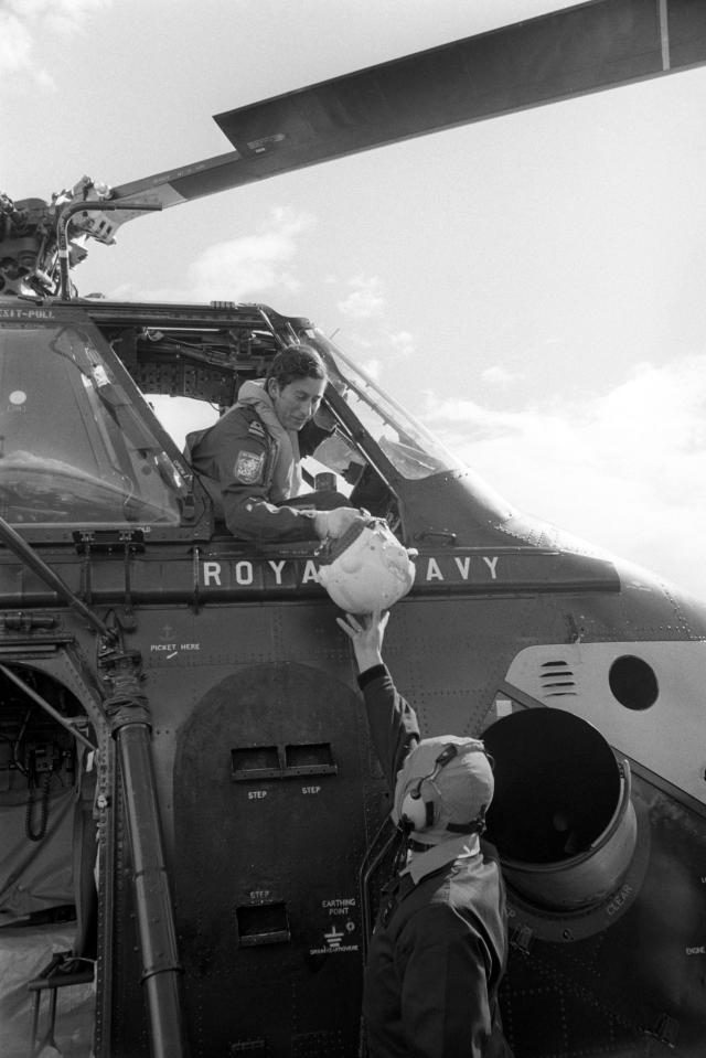  1974: Naval Lieutenant the Prince of Wales being handed his flying helmet by a ground crewman before going up for his first 'dual control' flight