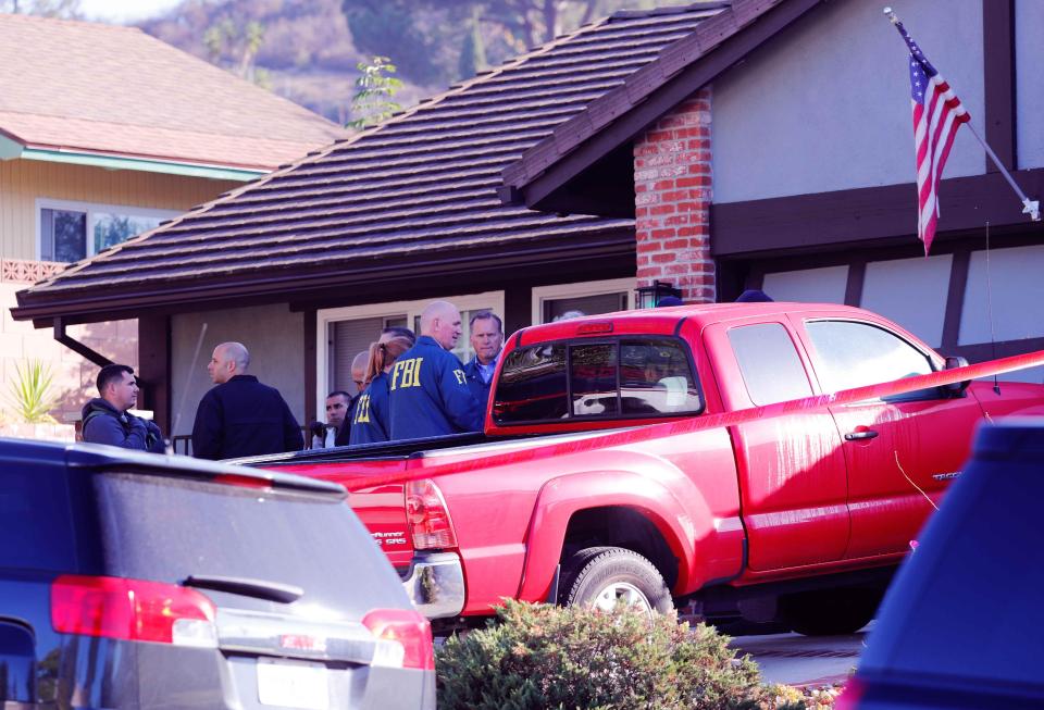  Police and FBI officers wait outside Long's house which is close to the Thousand Oak Bar