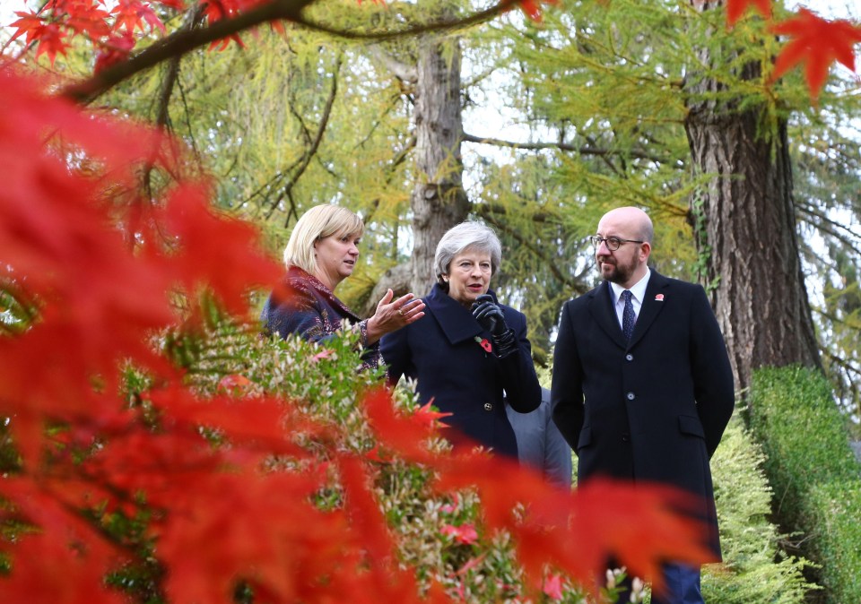 Theresa May (centre) walks at the St Symphorien Military Cemetery in Mons, Belgium, with Belgian Prime Minister Charles Michel and Liz Sweet, Director, External Relations, Western Europe Area, Commonwealth War Graves Commission