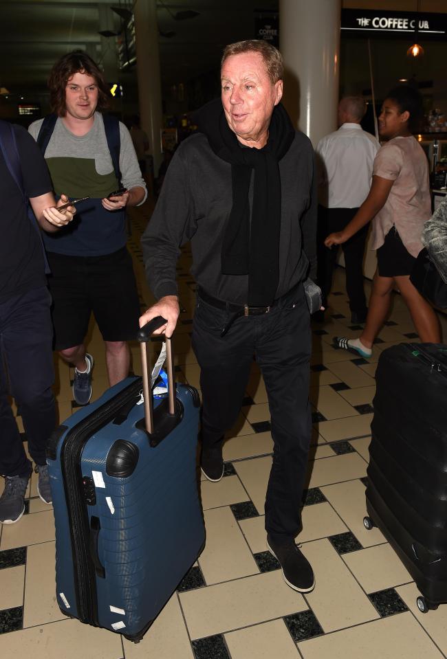  Harry looked relaxed with a jumper wrapped around his neck as he pulled his luggage