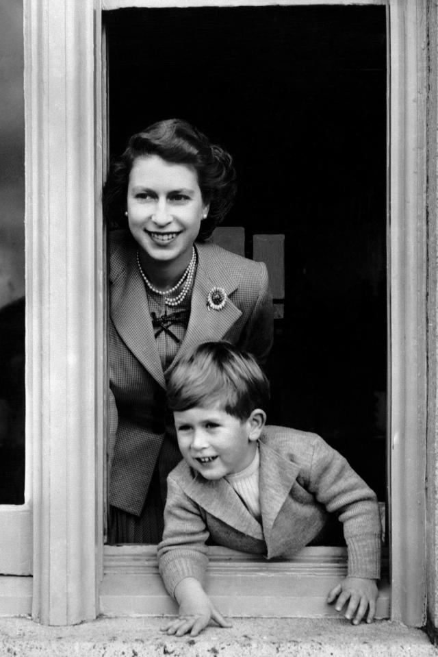  The Prince of Wales - seen here in 1952 - keeping a look out on his fourth birthday, as he leans from a window from Buckingham Palace with his mother, Queen Elizabeth II