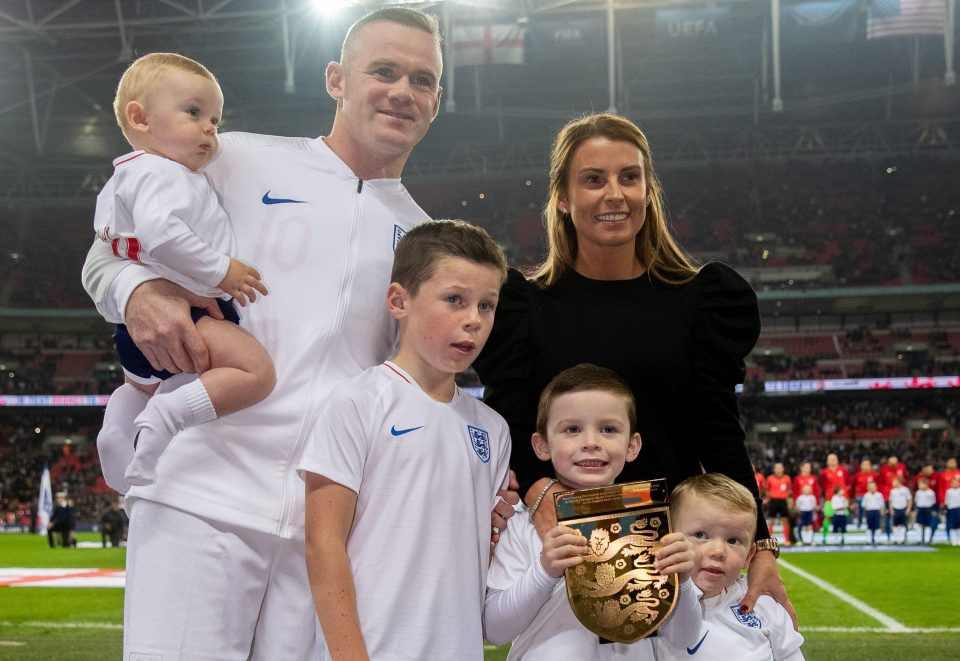  The family smile as Wayne is presented with a trophy to commemorate his 120 caps for England on Thursday