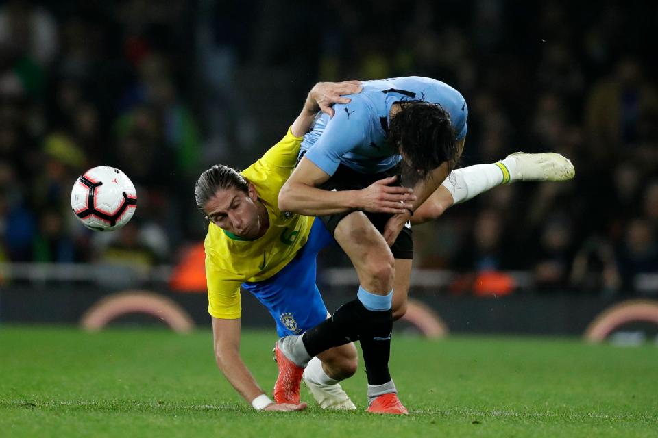  Brazil's Felipe Luis, left, clashes with Uruguay's Edinson Cavani