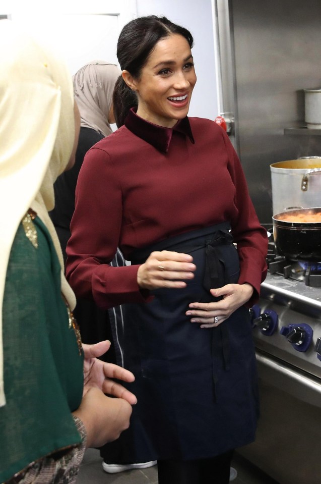 Meghan was seen holding her baby bump this morning