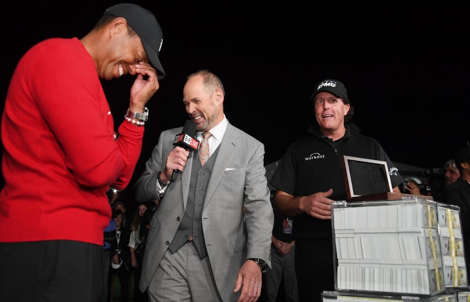  Tiger Woods laughs as Phil Mickelson collects his cash