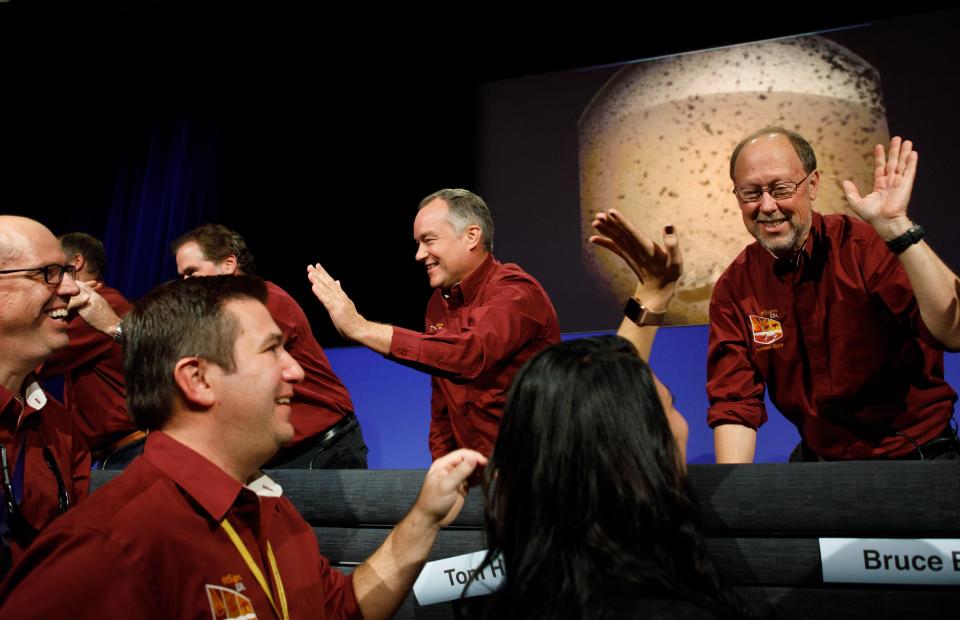  Flight team members give each other high-fives during a press conference at Nasa's Jet Propulsion Laboratory after the InSight spacecraft mission made its successful landing