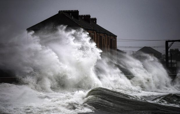 Waves crash in against the harbour wall in Saltcoats, Scotland.