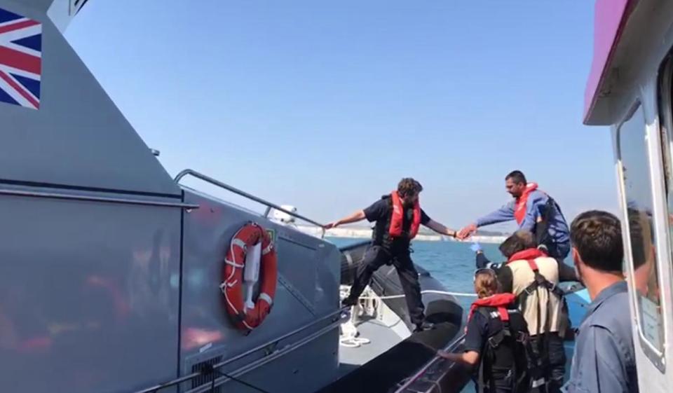  Border force rescue officers transferring a migrant (blue top) from Matt's boat to their vessel