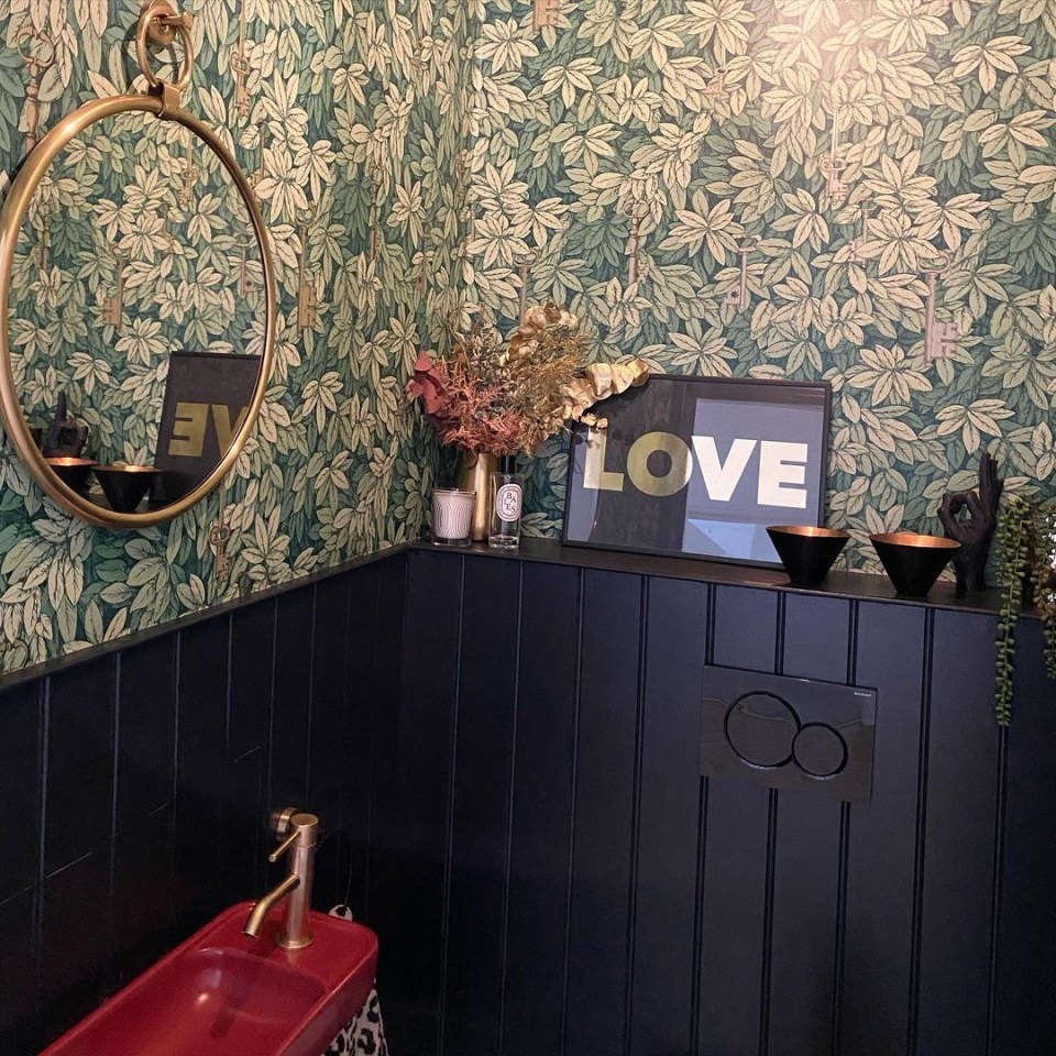 The singer’s bathroom featured floral-printed wallpaper and navy wooden panelling